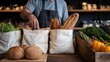 © Sitti - Baker placing fresh bread and produce into reusable bags at a market stall.
