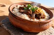 © firojprobd - Traditional middle eastern dish of rice and meat in a clay bowl
