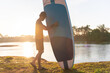 © tonjung - Paddleboarder walking towards the sea.Active with SUP board walking on the beach.