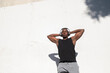 © KikoStock - Man enjoying music and resting against a white wall after exercising