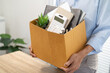 © Charlie's - Business man sending resignation letter and packing Stuff Resign Depress or carrying business cardboard box by desk in office. Change of job or fired from company