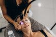© Roman - Woman receiving led uv light eyelash extensions