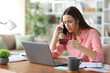© Antonioguillem - Worried tele worker paying online talking on phone