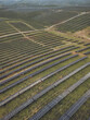 © AmazingAerialAgency - Aerial view of rows and rows of solar panels stretch across the landscape, capturing the sun's rays in a symphony of light and shadow, Lagos, Faro District, Portugal.