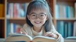 © vefimov - Child with glasses focused on book pages.