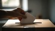 © Mia - Hand casting ballot into wooden box at polling station with natural light