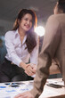 © Tj - Business women shaking hands, concluding a successful partnership agreement in an office setting, with scattered charts and a smartphone on the desk, symbolizing teamwork and corporate success