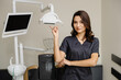 © nazariykarkhut - Smiling female dentist looking at the camera in dental clinic