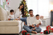 © New Africa - Parents and their cute twin babies with Christmas gifts at home