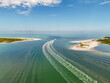 © AmazingAerialAgency - Aerial view of boats leaving white wakes in the turquoise waters between the sandy shores of Honeymoon Island and Caladesi Island, Dunedin, Florida, United States.
