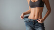 © Mrammon - Slim woman weight loss loose jeans flat stomach fit body healthy lifestyle slim waist toned abs diet success active female slim woman loose jeans showing flat stomach and slim waist, fit body