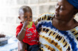 © Alvaro Lavin/Stocksy - African mother holding baby eating watermelon in Senegal