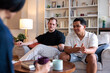 © Jovo Jovanovic/Stocksy - Two men converse with a person holding a mug.