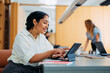 © OchreOchre/Stocksy - Smiling Woman Works On Tablet In Modern Office