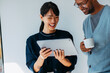 © OchreOchre/Stocksy - Happy Colleagues Looking at Tablet With Coffee