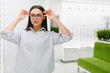 © Serhii - Woman trying on eyeglasses in optical shop