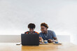 © Daniel Gonzalez/Stocksy - Young African friends sharing laptop in Stone Town cafe