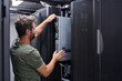 © .shock - IT technician installing server hardware in a data center rack performing maintenance and configuration