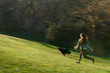 © Leire Cavia/Stocksy - Blurred image of dog and owner at the park