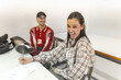 © Lupe Rodriguez/Stocksy - Two students making funny faces at desks in classroom