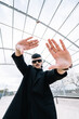 © Carbonero Stock - Concepts of personality, pride, Generation Z. Low-angle portrait of a non binary caucasian adult posing with hands framing camera outdoors.