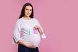 © New Africa - Choosing name for baby. Pregnant woman holding notes with words Boy and Girl on pink background, space for text