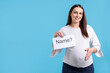 © New Africa - Pregnant woman holding card with word Name and question mark on light blue background, space for text