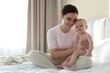 © New Africa - Mother and her cute baby on bed at home. Space for text