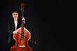 © New Africa - Girl with double bass and bow on black background, space for text