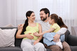 © New Africa - Pregnant woman, her husband and daughter on sofa at home