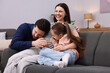 © New Africa - Pregnant woman, her husband and daughter on sofa at home