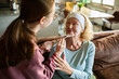 © Geber86 - Granddaughter applying face mask to grandmother at home