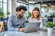 © Artem Onoprienko - Two young business people, colleagues use laptops in modern office. Happy team working together, discussing solutions