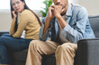 © Pormezz - Family problem concept. Tension in relationship between married couple, husband and wife staying sitting separate after quarrel in the living room.