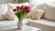 © OTaone - Vibrant Red Tulips in a White Vase Centered on a Modern Coffee Table Surrounded by Cozy Beige Sofa Cushions in a Bright Living Room
