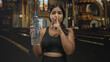 © Krakenimages.com - Sporty young woman holds large water bottle and presses finger to lips for silence in a building; quiet reverence.