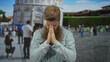 © Krakenimages.com - Bearded man pressing hands together in prayer at colorful leaning tower building outdoors in pisa; serenity.
