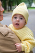© phpetrunina14 - Mother Holding Baby in Yellow Outfit at Park early autumn