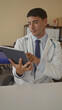 © Krakenimages.com - Man doctor scrolling through tablet with stethoscope draped on neck and wearing lab coat in clinic room; concentration.