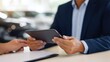 © Mary - Businessman using tablet while discussing with colleague at desk