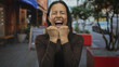 © Krakenimages.com - Woman expressing joyful excitement on a lively urban street with vibrant surroundings and cheerful atmosphere, enhancing the feeling of happiness outdoors.