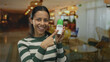 © Krakenimages.com - Woman smiling holding deodorant in hotel lobby, showcasing hygiene product in a relaxed indoor setting with vibrant lighting and elegant decor.