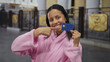 © Krakenimages.com - Young woman in pink bathrobe outdoors smiling and holding a credit card, highlighting modern casual lifestyle and financial freedom
