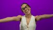 © Krakenimages.com - Woman smiling on an isolated purple background conveys happiness and positivity, wearing glasses and a white top, expressing warmth and friendliness in a confident manner.