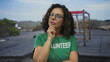 © Krakenimages.com - Woman volunteer in green shirt thinking outdoors with gym equipment in background.