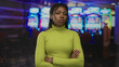 © Krakenimages.com - African american woman arms crossed facing slot machines in casino building; disappointment quiet resolve.