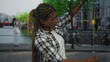 © Krakenimages.com - African american woman holding smartphone raising arms for selfie in street near canal and bicycles; travel memory curiosity.