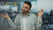 © Krakenimages.com - Young man in airport terminal showing playful expression in busy waiting area with travelers seated in background hinting at a lively travel atmosphere.