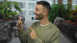 © Krakenimages.com - Smiling man pointing in an urban street with greenery and modern buildings in the background showing a positive and natural expression on his face outdoors.