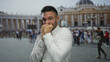 © Krakenimages.com - Young man in white shirt appears anxious in front of st. peter's basilica, surrounded by tourists in vatican city, clutching face and hands, capturing travel emotion vividly.